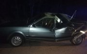 srebrny samochód osobowy  sojący na drodze  z uszkodzona karoseria, peknieta na pół