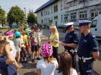 zdjęcia przedstawiają egzamin na kartę rowerową na terenie SP nr 1 w Opocznie. Na zdjęciach widać umundurowanych policjantów, oraz dzieci, które jadą rowerem po wyznaczonym torze
