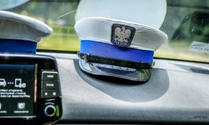 czapka policji ruchu drogowego leżąca na desce rozdzielczej radiowozu