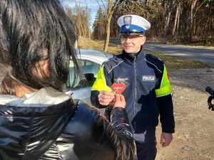 walentynkowa akcja policji, umundurowani policjanci przekazują kierowcom serduszka z napisem Zwolnij, jak kocha to poczeka